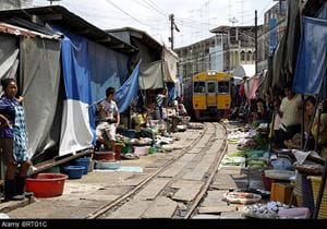 Thailand's Maeklong Railway inches its way through a market, with stalls on either side of the rails